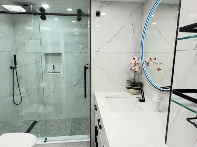 a bathroom with a sink a toilet and shower