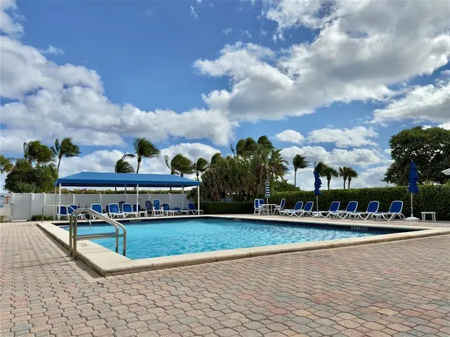a view of a patio with table and chairs potted plants and large tree