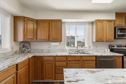 a kitchen with granite countertop wooden cabinets a sink and a stove