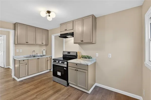 a kitchen with a sink cabinets and wooden floor