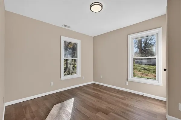 an empty room with windows and closet