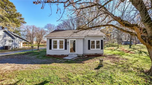 a view of a yard in front of a house with large tree