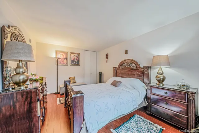 a bedroom with a bed and a lamp on dresser