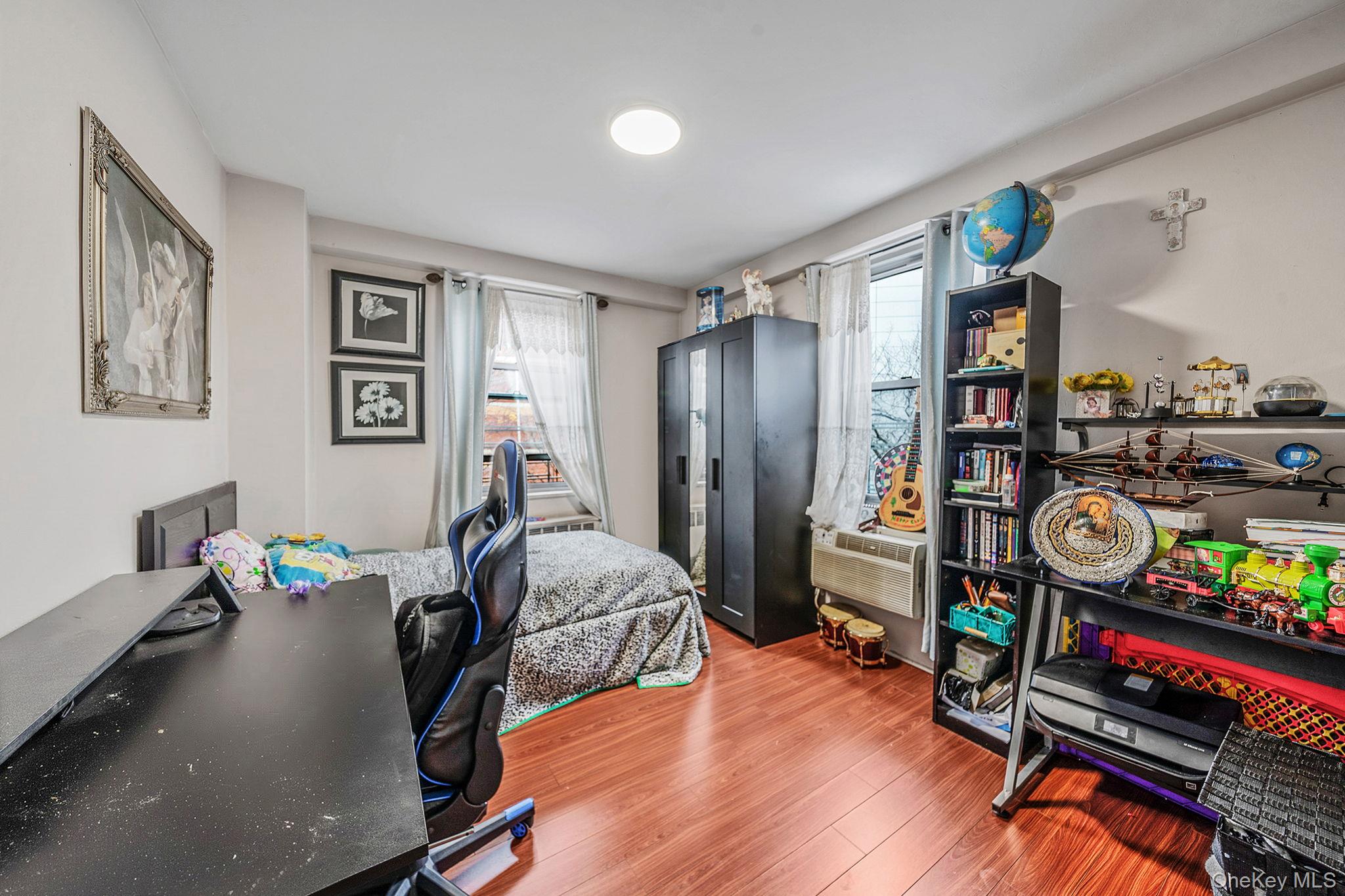 61-25 97th Street, Unit 2B Queens, NY 11374 - Photo 15 of 22 a bedroom with furniture and a book shelf