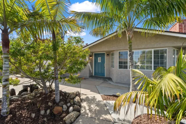 a yellow house with a palm tree in front of it