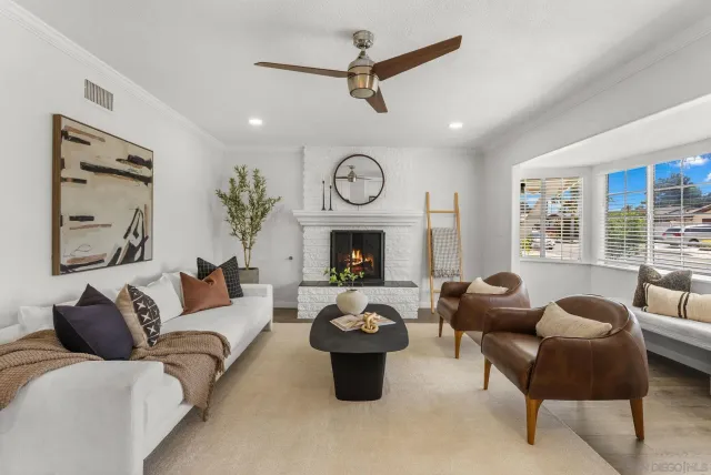 a living room with furniture a fireplace and a large window