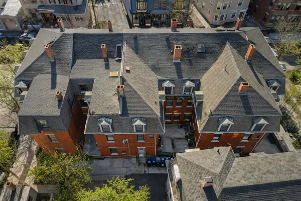 an aerial view of a house with barbeque grill and a table