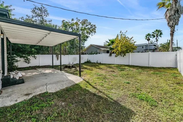 a view of a house with backyard and a tree