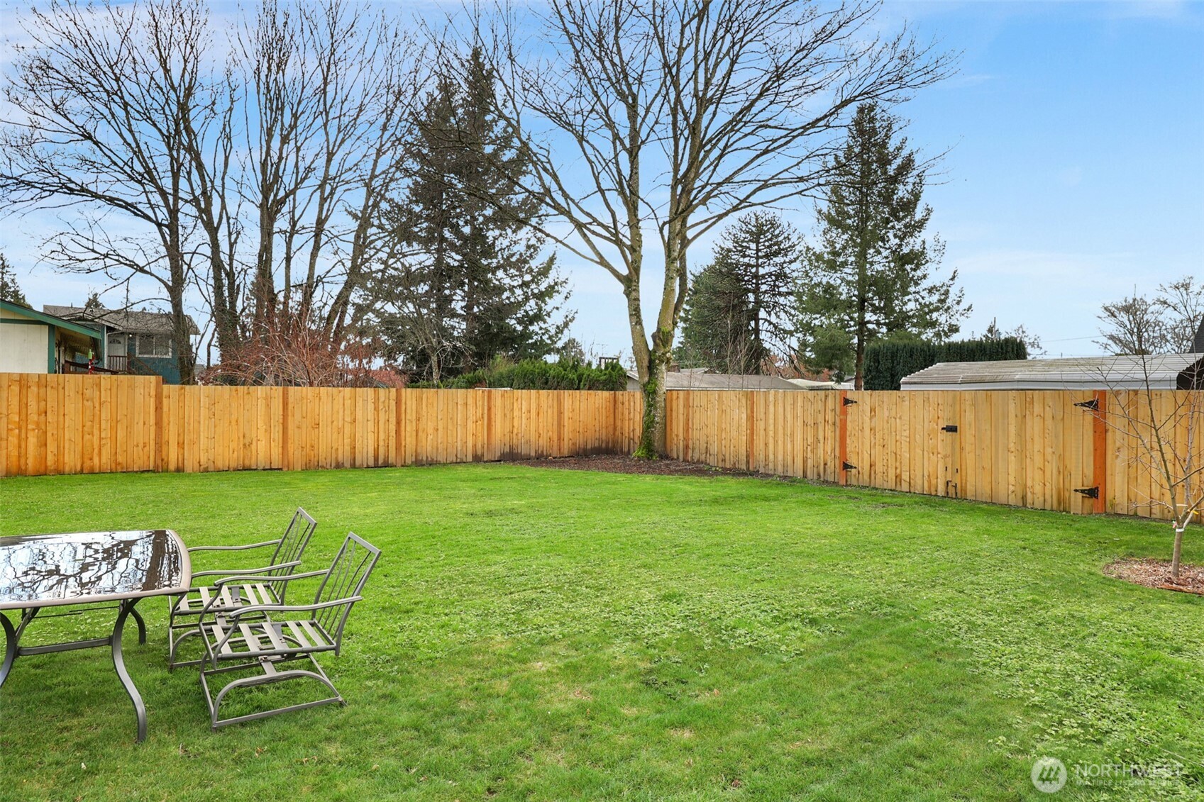 402 Haines Street Sedro-Woolley, WA 98284 - Photo 22 of 24 a view of a backyard with table and chairs and wooden fence