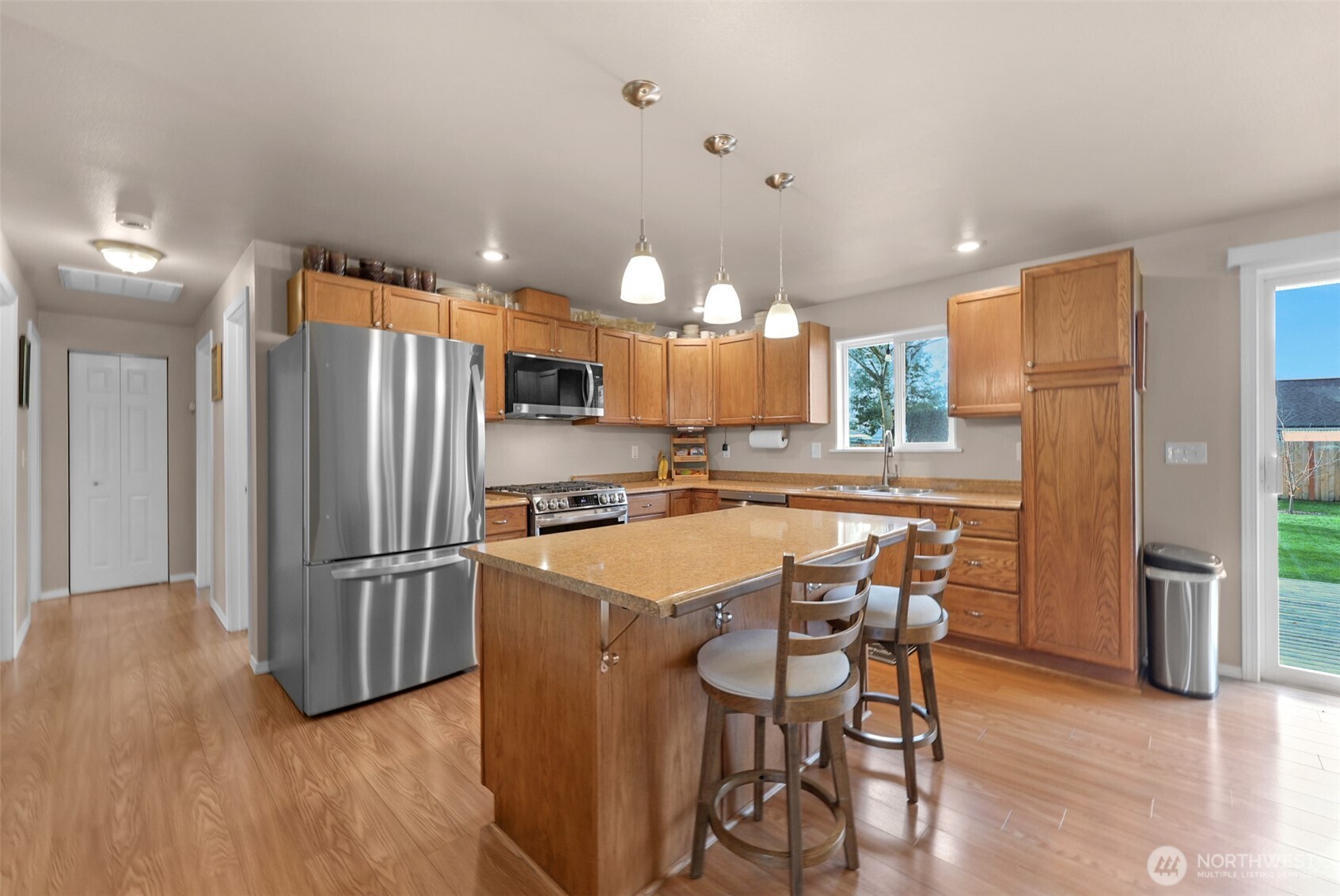 402 Haines Street Sedro-Woolley, WA 98284 - Photo 6 of 24 a kitchen with stainless steel appliances a refrigerator a stove a sink a dining table and chairs with wooden floor