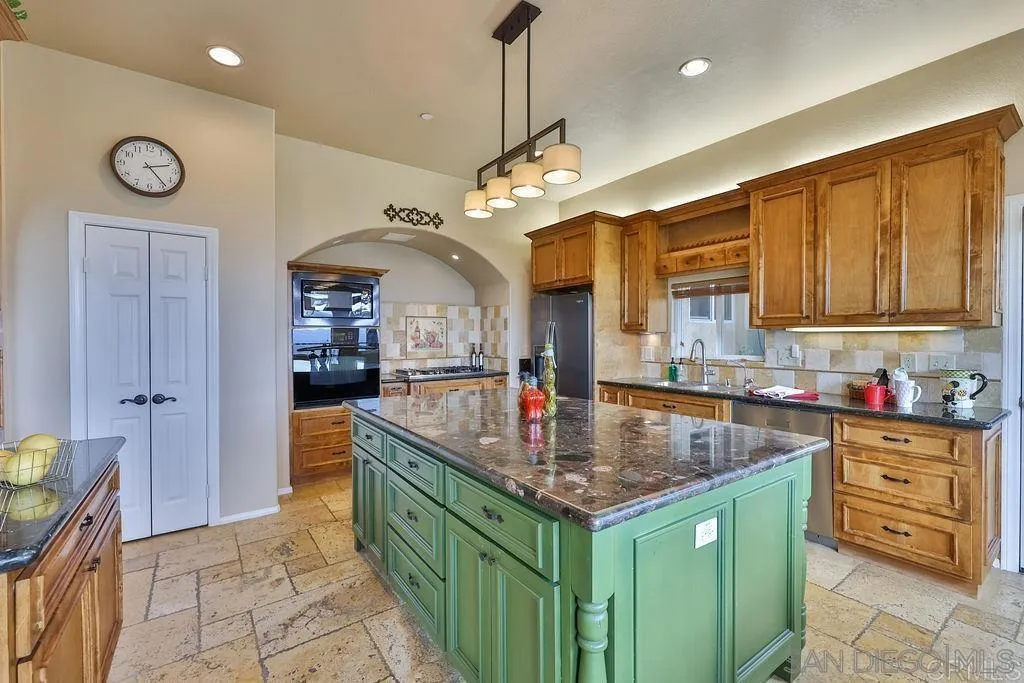 1152 Stoneridge Road El Cajon, CA 92021 - Photo 61 of 71 a kitchen with stainless steel appliances granite countertop a sink a oven and a wooden cabinets