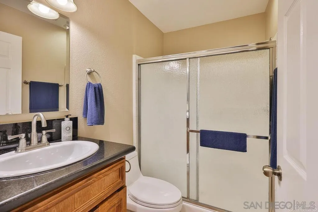 1152 Stoneridge Road El Cajon, CA 92021 - Photo 63 of 71 a bathroom with a granite countertop sink toilet a mirror and shower