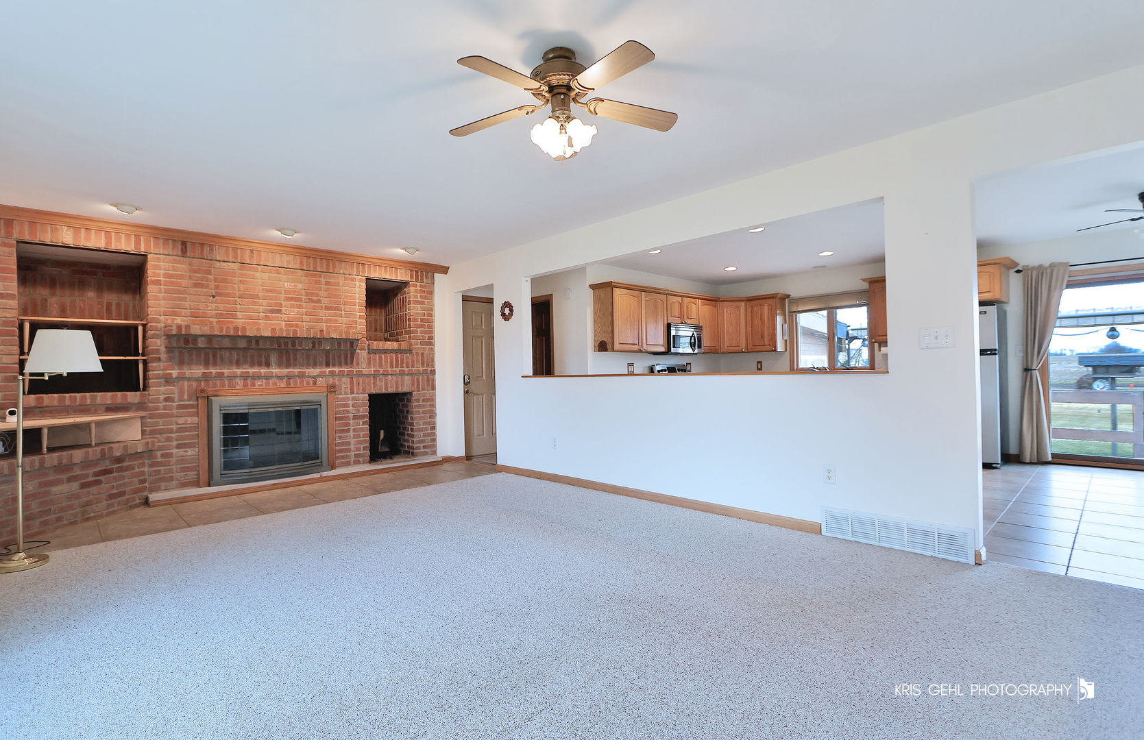 3409 Chukar Road Woodstock, IL 60098 - Photo 2 of 15 a view of a livingroom with a fireplace a chandelier a wooden table and chairs