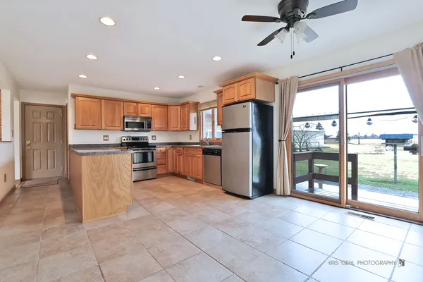 a kitchen with stainless steel appliances granite countertop a refrigerator and a stove top oven