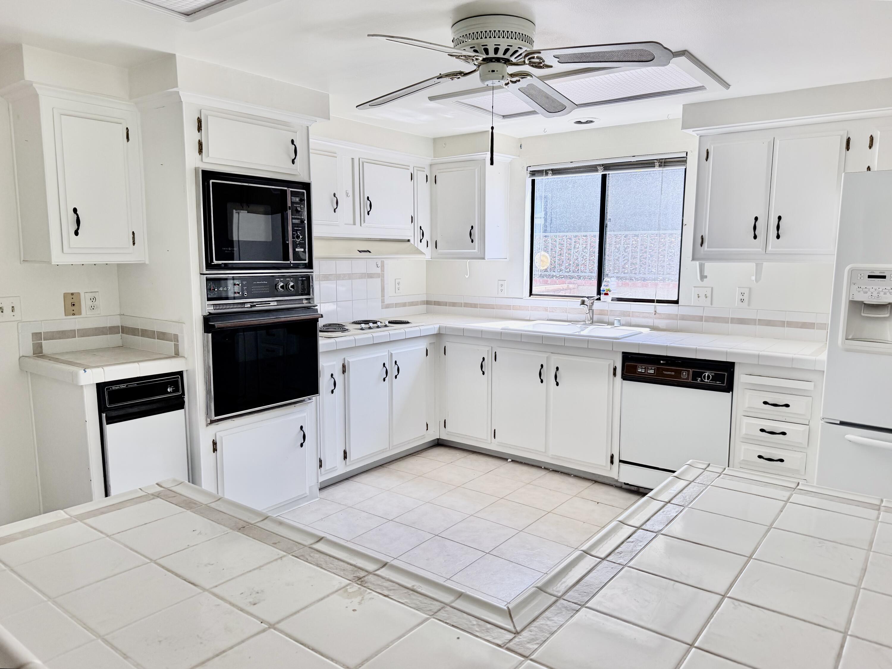 74361 Angel Camp Road Palm Desert, CA 92260 - Photo 3 of 12 a kitchen with stainless steel appliances granite countertop a stove a sink and a refrigerator