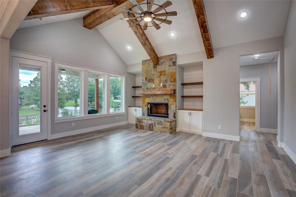 405 Door Key Ranch Road Trinidad, TX 75163 - Photo 4 of 28 Unfurnished living room featuring beam ceiling, ceiling fan, light hardwood / wood-style floors, a fireplace, and high vaulted ceiling