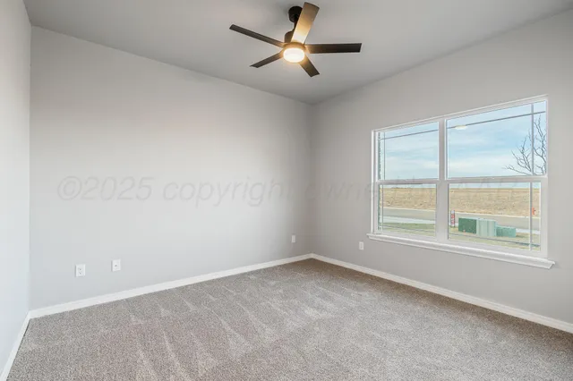 an empty room with a window and a fan