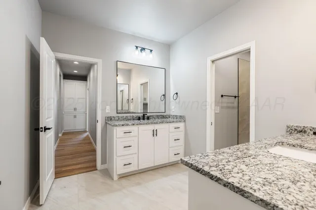 a bathroom with a granite countertop sink and a mirror