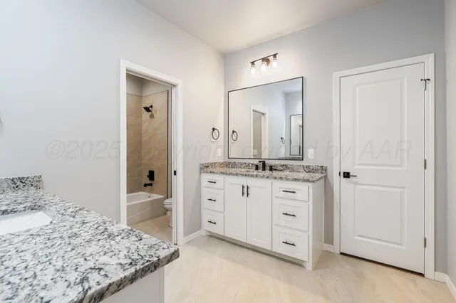 a spacious bathroom with a granite countertop sink and a mirror