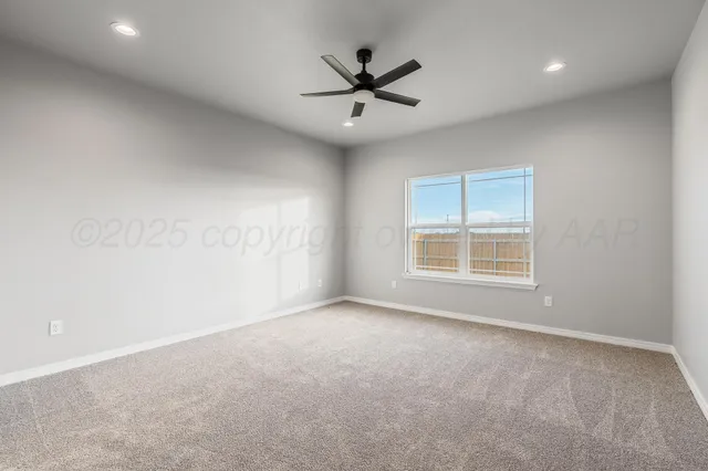 an empty room with a ceiling fan and window