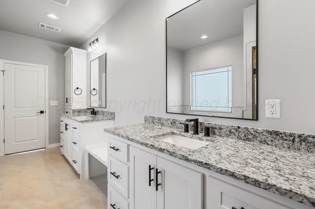 a bathroom with double sink and a mirror