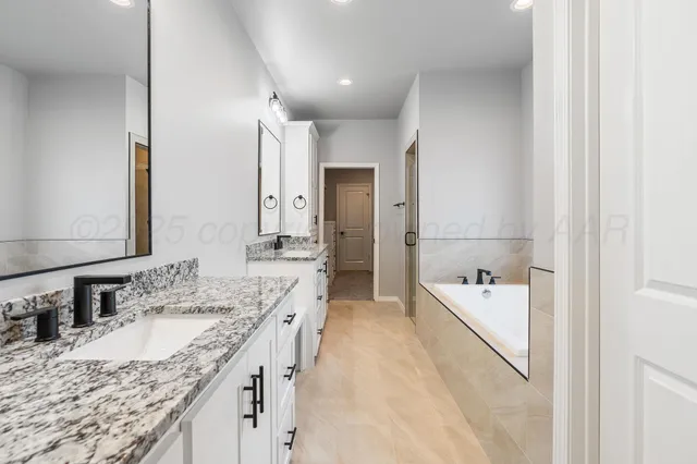 a spacious bathroom with a granite countertop sink and a mirror