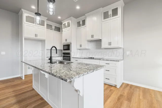 a kitchen with stainless steel appliances granite countertop a sink stove and cabinets