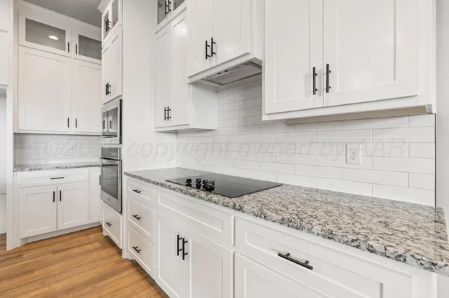 a kitchen with white cabinets and white appliances