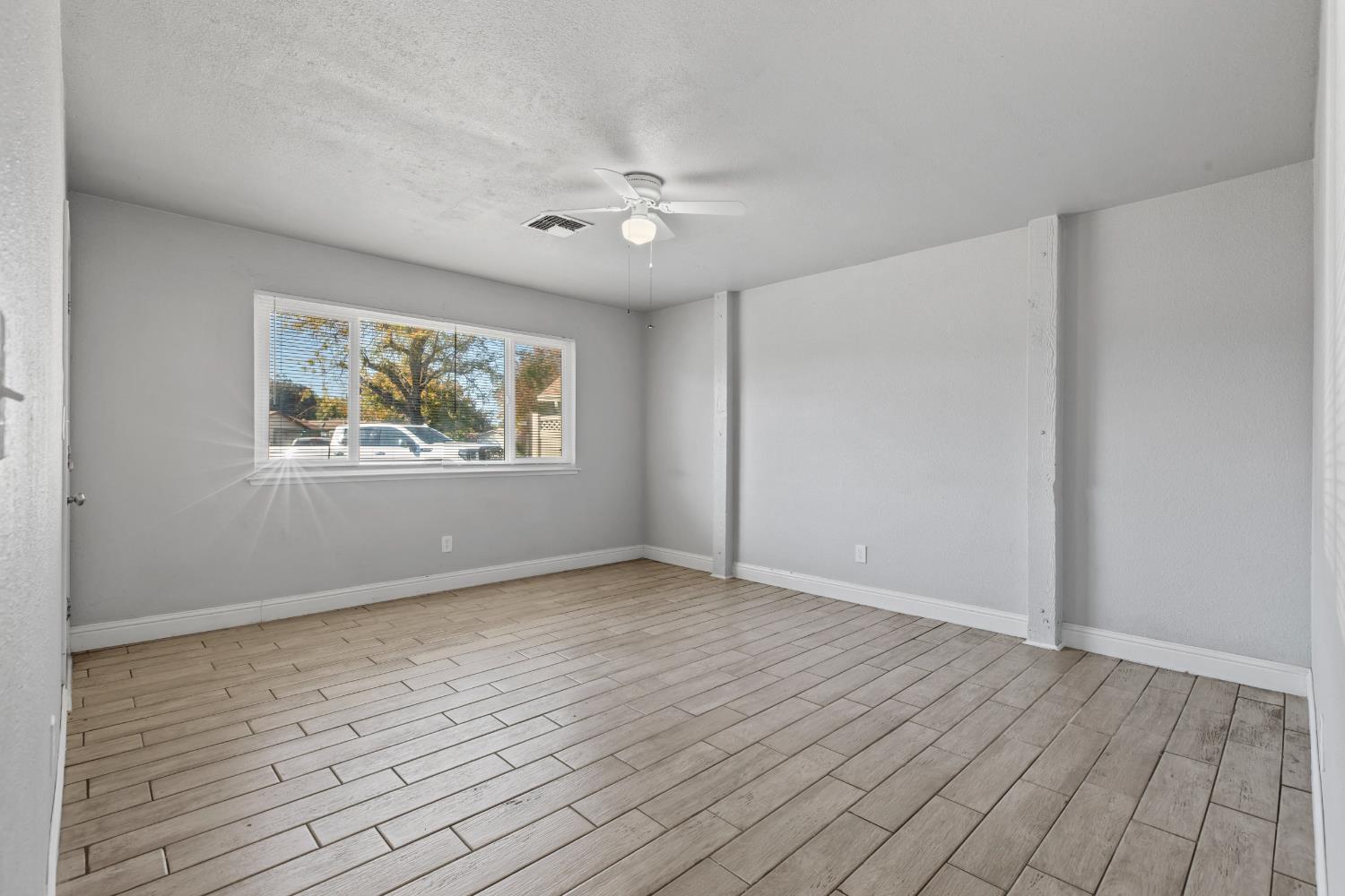 2525 Orwell Court Modesto, CA 95354 - Photo 7 of 33 a view of an empty room with wooden floor and a window
