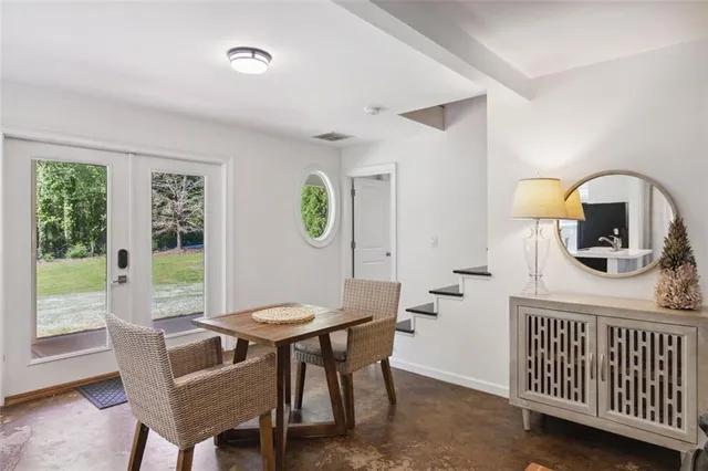 a living room with furniture a flat screen tv and kitchen view