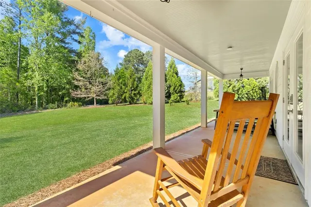 a view of a two chairs in the patio next to a yard