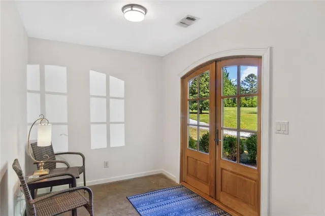 a living room with furniture a large window and wooden floor