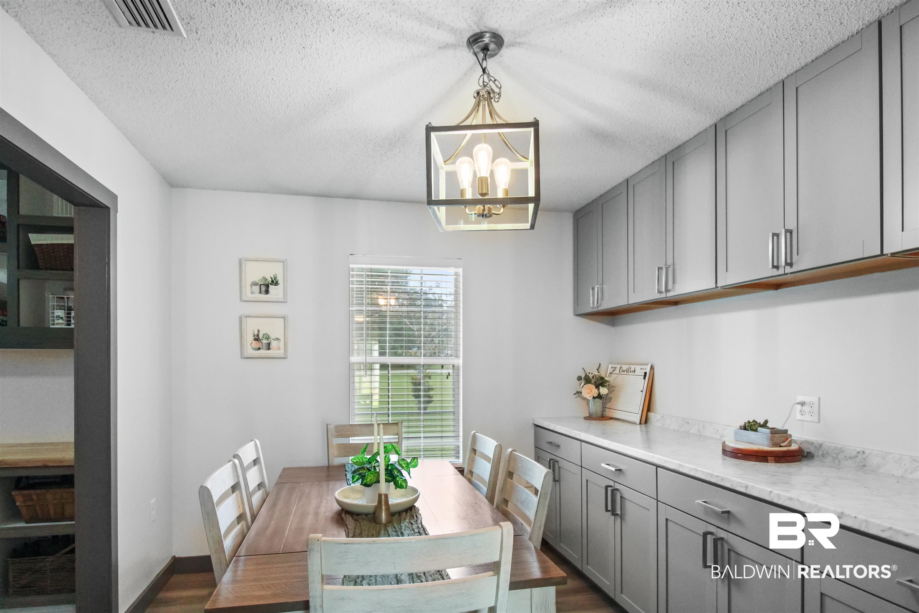 26850 Timber Lane Elberta, AL 36530 - Photo 6 of 33 Dining room featuring a chandelier, dark wood-style floors, and a textured ceiling