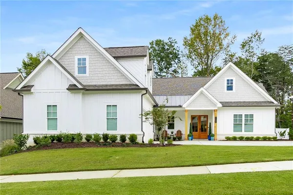 a front view of a house with a garden and trees