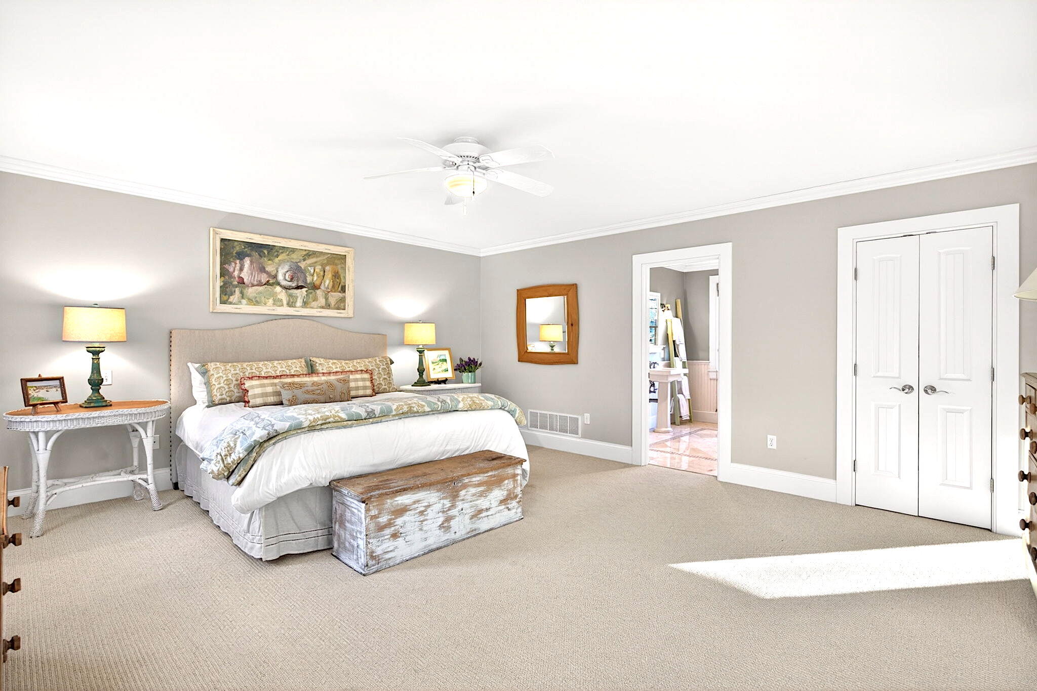 205 Little River Road Cotuit, MA 02635 - Photo 25 of 60 a spacious bedroom with a bed a table and painting