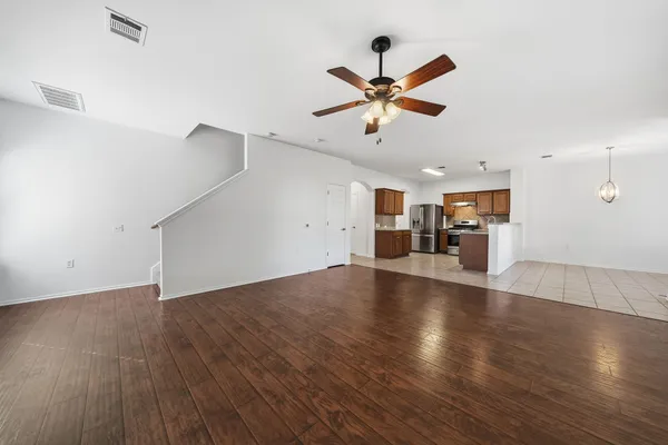 a view of a livingroom with a ceiling fan and wooden floor