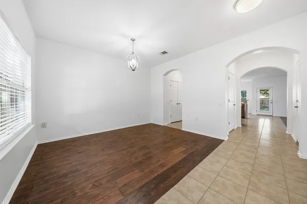 a view of a big room with wooden floor and windows