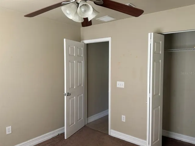 a view of a hallway with a chandelier fan