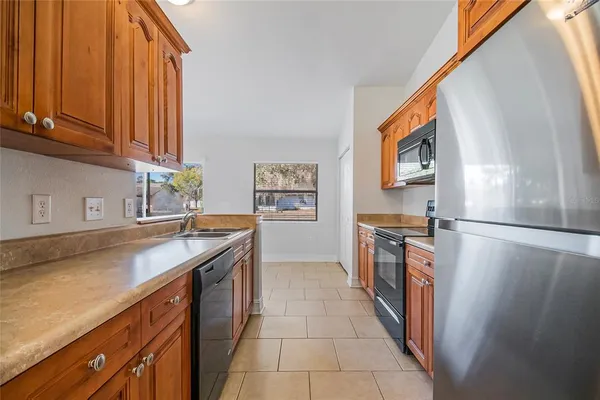 a kitchen with stainless steel appliances granite countertop a refrigerator and a stove top oven