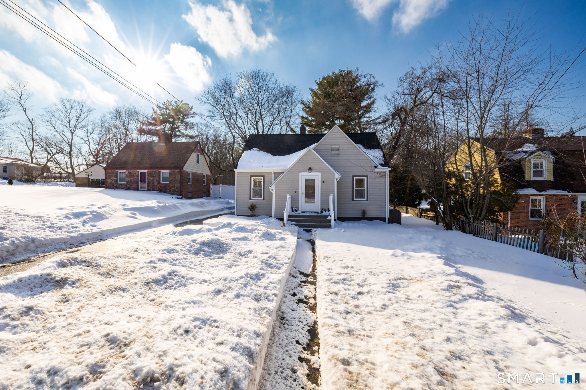 681 Main Street Cromwell, CT 06416 - Photo 27 of 39 a view of a white house with a yard covered in snow