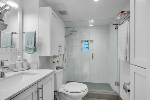 a bathroom with a sink a toilet and shower