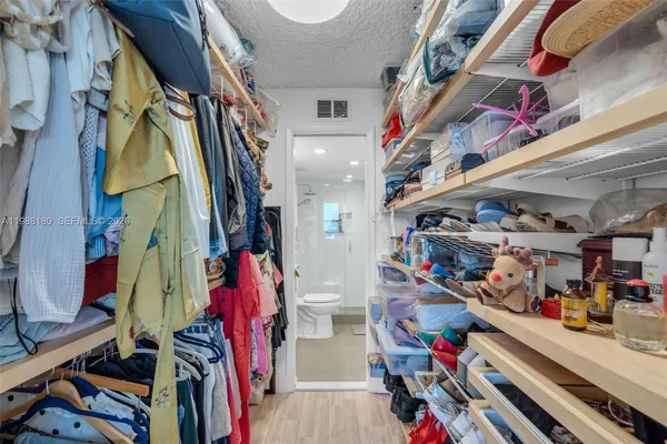 a view of walk in closet with clothes and shoes