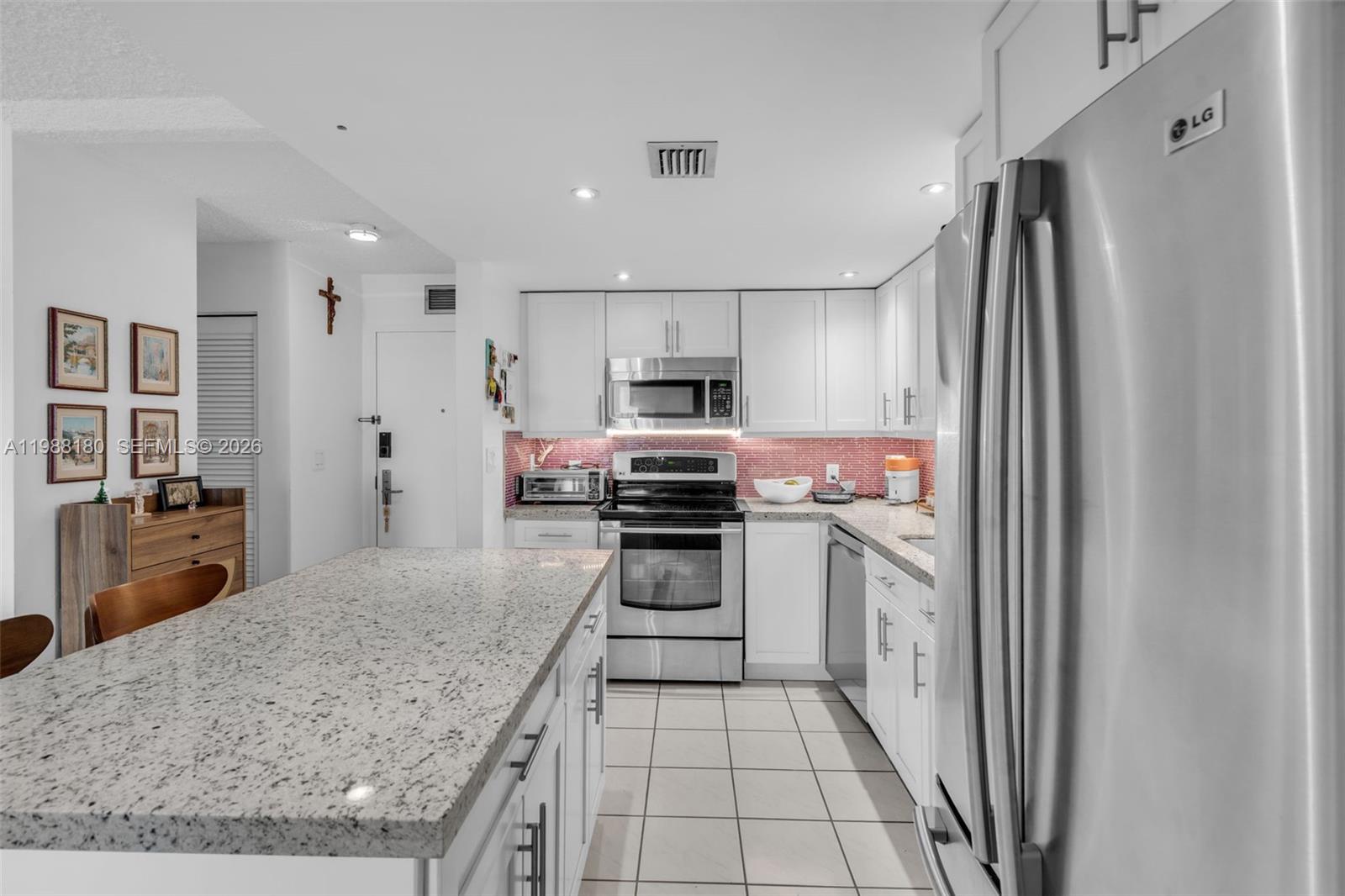 150 Southeast 25th Road, Unit 8H Miami, FL 33129 - Photo 32 of 41 a kitchen with granite countertop a refrigerator and a sink