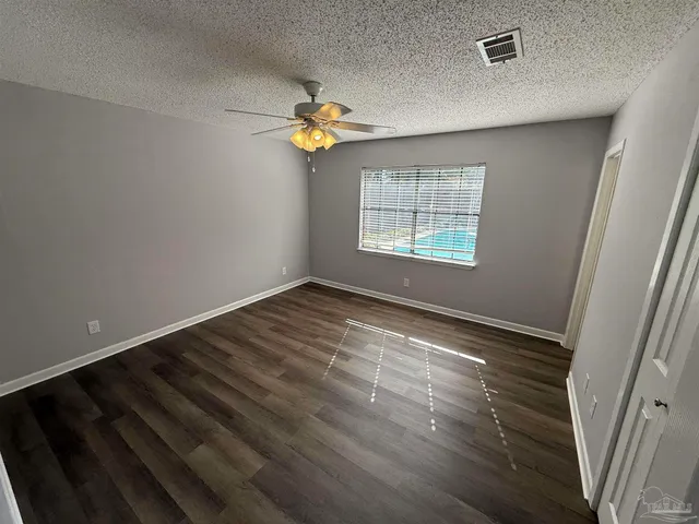 en empty room with windows and chandelier