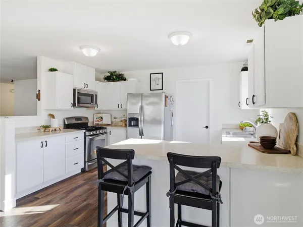 a kitchen with white cabinets and stainless steel appliances