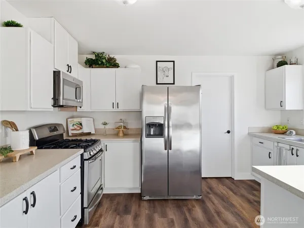 a kitchen with stainless steel appliances a refrigerator sink and white cabinets