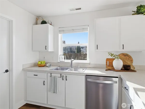 a kitchen with stainless steel appliances granite countertop a sink a stove and cabinets