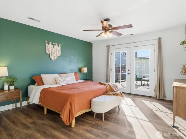 a bedroom with a large bed chandelier and a window