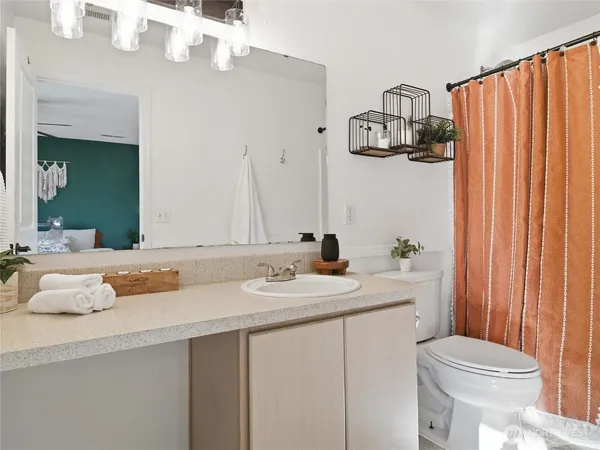 a bathroom with a sink and mirror with toilet