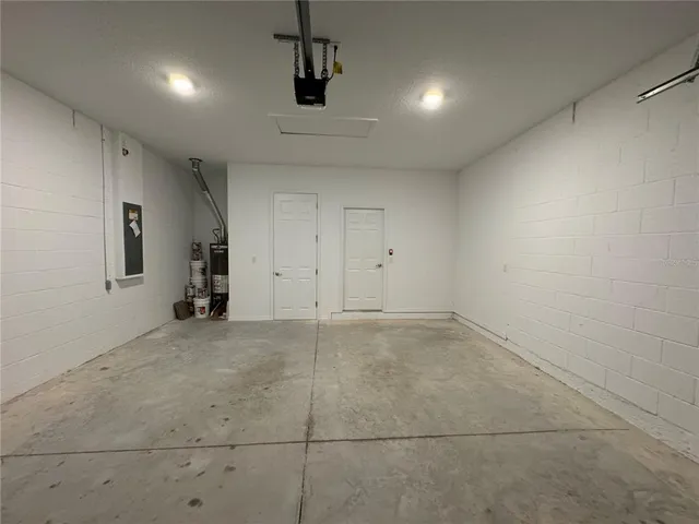 a view of large green field with large tree in front of it